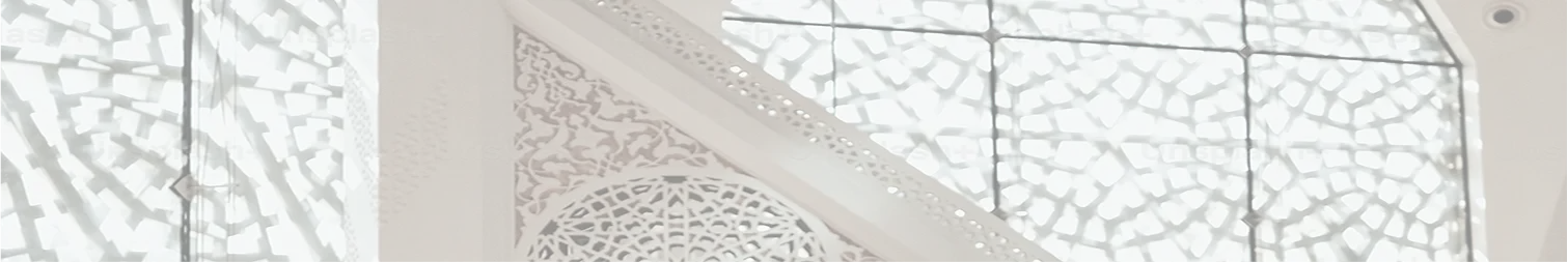 A sunlit mosque with geometric patterns and Arabic calligraphy